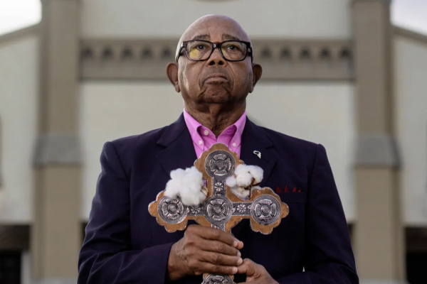 Descendant Joseph Stewart holding cross with cotton